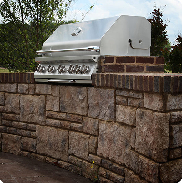 Gas-powered grill on an open stone kitchen countertop, ready for outdoor cooking and grilling
