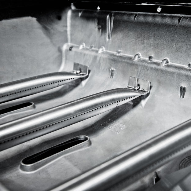 Close-up of BroilKing Baron S 590 IR grill's dual tube side burners, providing intense heat and precise cooking control