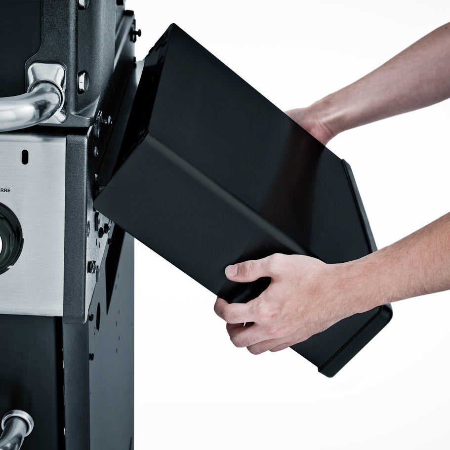 Close-up of BroilKing Crown 420 grill with a person folding down the side shelf for compact storage